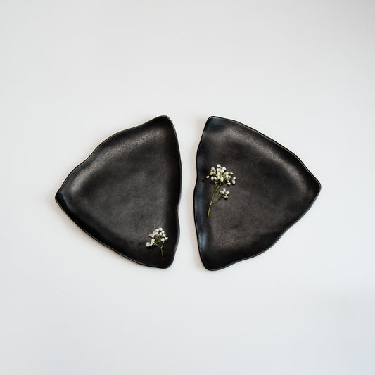 two black triangular organic plates suitible for cake pieces and other desserts